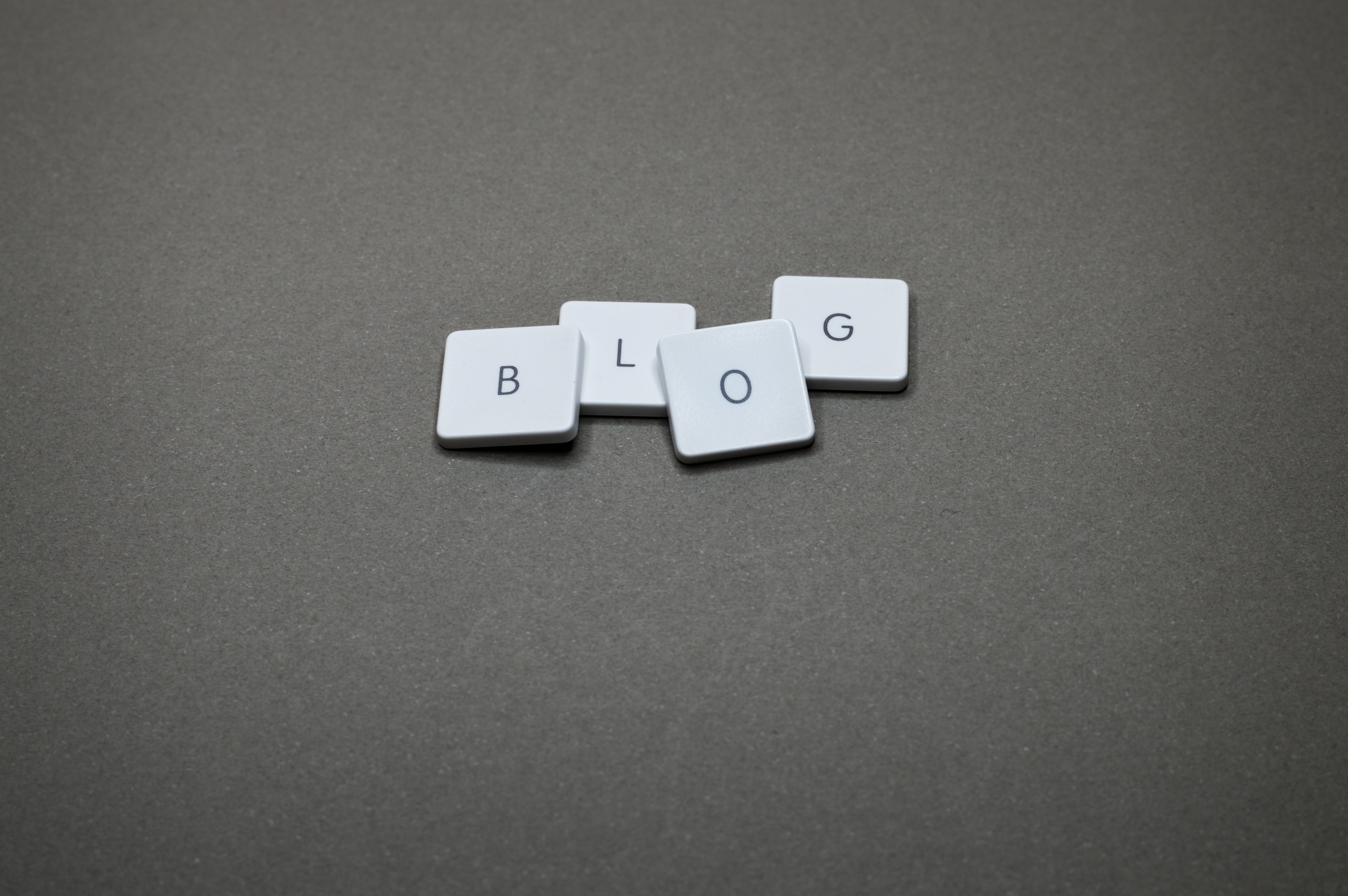 Teclas separadas de una laptop BLOG sobre un fondo gris para la entrada de un artículo sobre redacción SEO para blogs